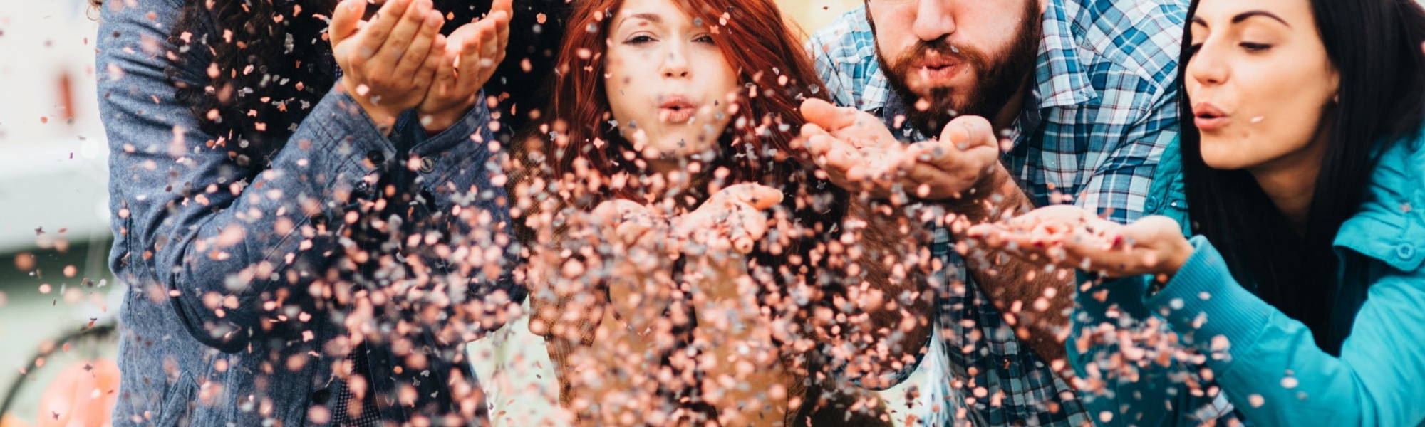Team of millennials blowing glitter confetti at candcsearch boutique recruitment agency 